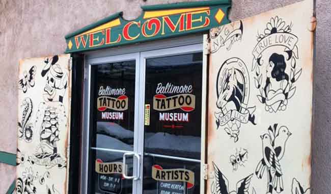 Photo of front entrance to Baltimore Tattoo Museum with artwork samples and colorful welcome sign, 1534 Eastern Avenue, Fell's Point, MD 21231